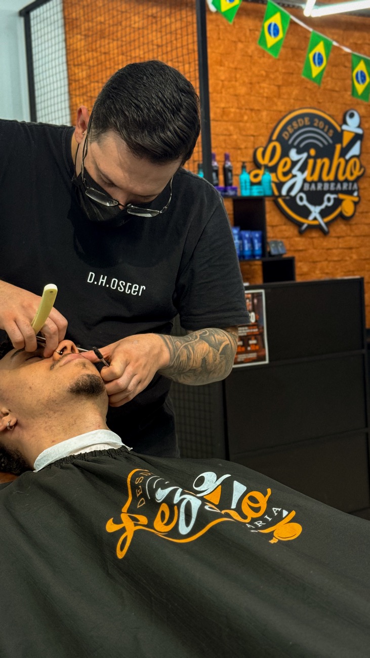 Barbeiro passando a navalha no cliente